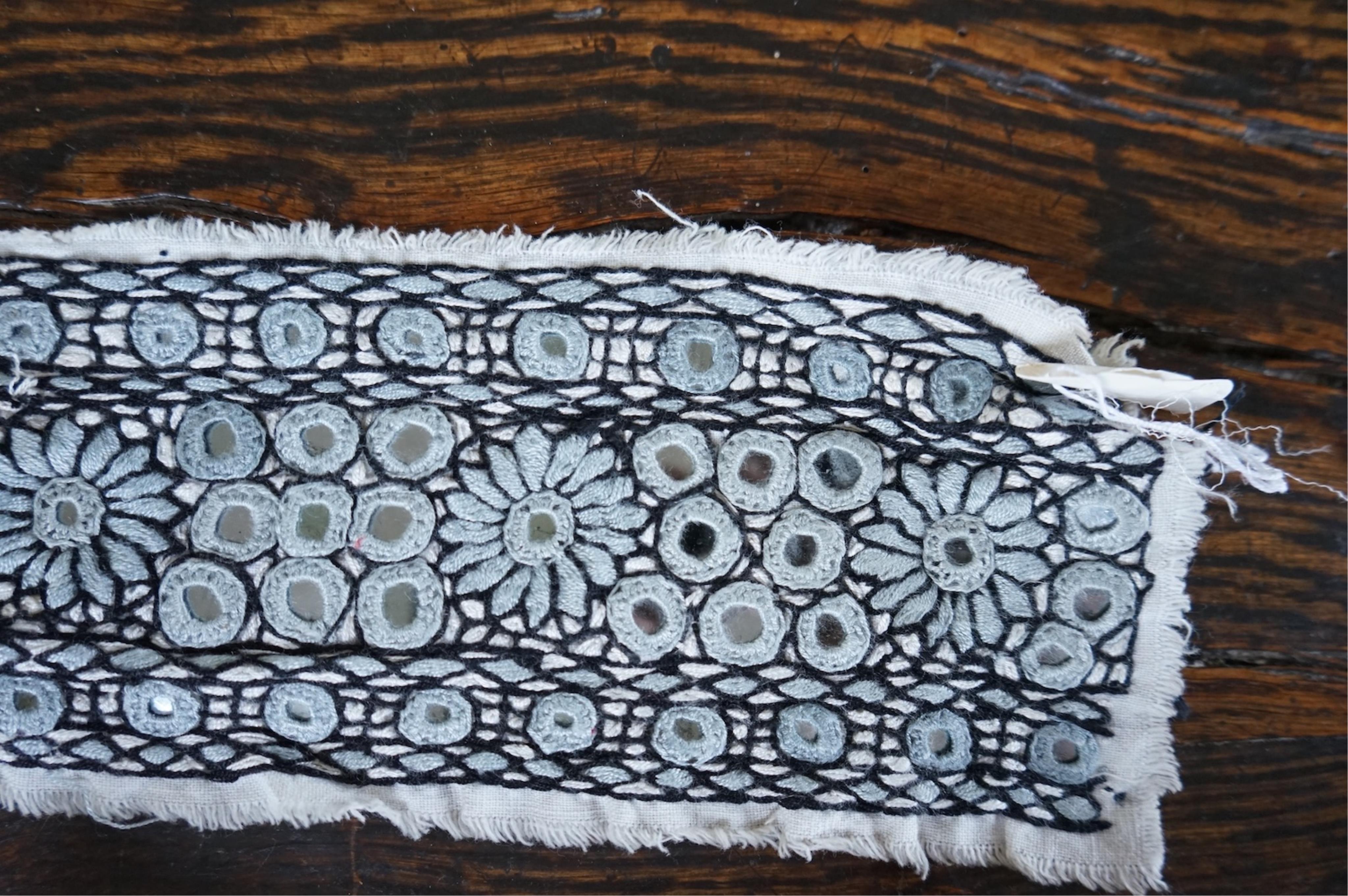 A long narrow length of grey Ikat woven fabric, a roll of Indian mirrored edging, a geometric batik printed length and a woven paisley ‘style’ tasselled stole. (4). Batik 392cm long x 108cm wide., Condition - good, all a